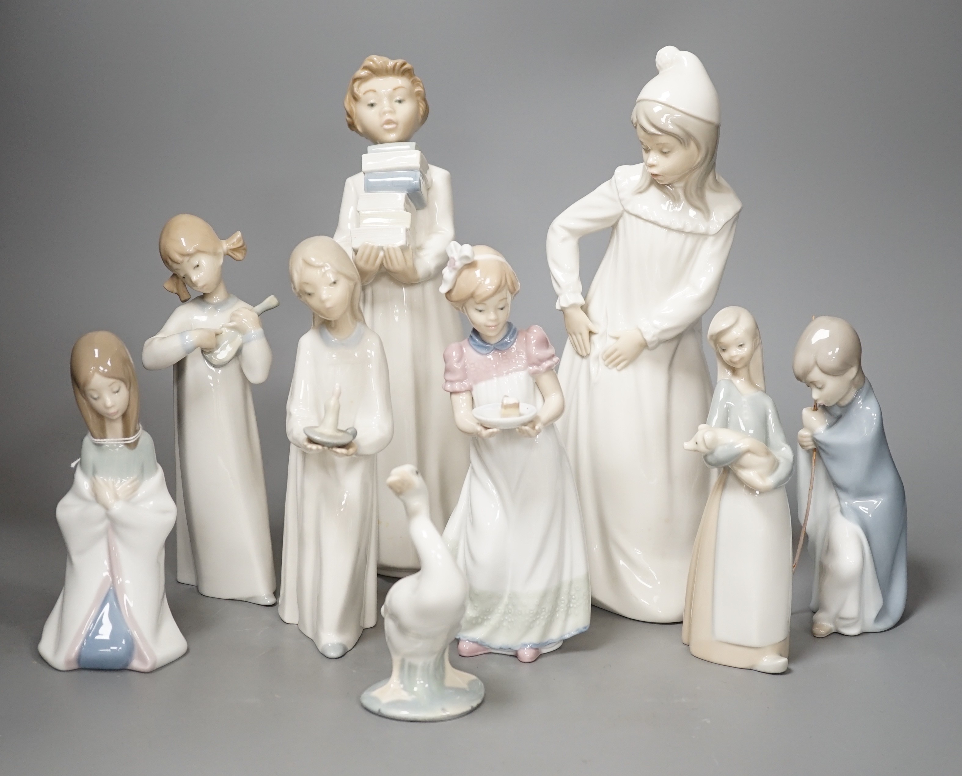 Seven Lladro figures together with two Nao figures. Tallest 29cm